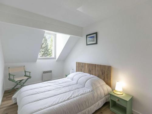 une chambre avec un grand lit blanc et une chaise dans l'établissement T3 calme, 6 pers, terrasse, tout équipé - FR-1-402-117, à Esquièze - Sère