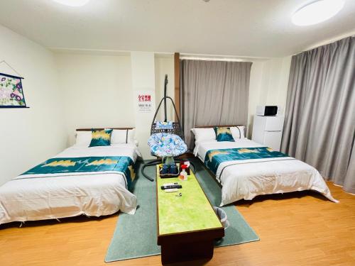 1 dormitorio con 2 camas y mesa. en 福宿 Fukuinn 302号室, en Takamatsu