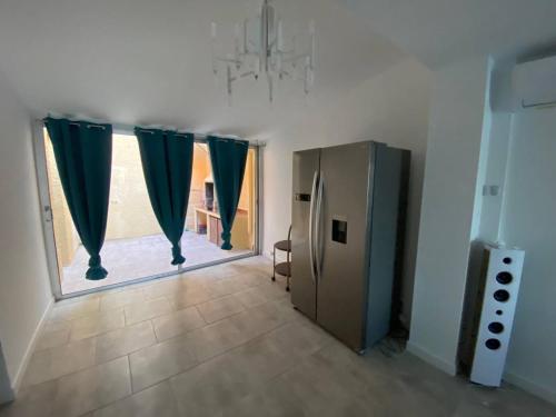 a room with a refrigerator and a window with curtains at Marina 5P avec piscine et terrasses, 4 chambres, clim, parking, proche plage et commerces, Port Barcarès - FR-1-81-554 in Le Barcarès