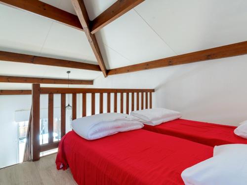 - une chambre avec un lit rouge et des oreillers blancs dans l'établissement Maison 6 pers. à Biscarrosse Plage - Proche mer, quartier calme, cour fermée, tout confort - FR-1-521-202, à Biscarrosse