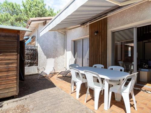 - une table et des chaises blanches sur la terrasse dans l'établissement Maison 6 pers. à Biscarrosse Plage - Proche mer, quartier calme, cour fermée, tout confort - FR-1-521-202, à Biscarrosse
