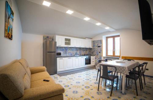 a living room with a table and a kitchen at CASA ALBA D'ORO in Scala