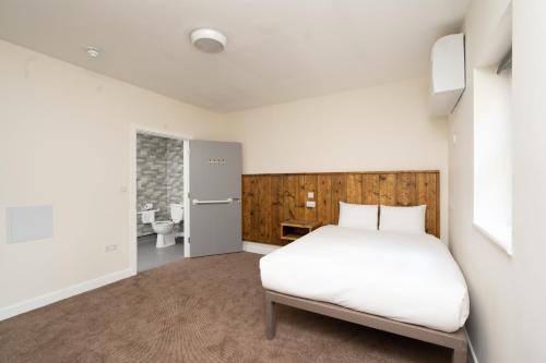 a bedroom with a bed and a bathroom at Hotel DC, Stratford in London