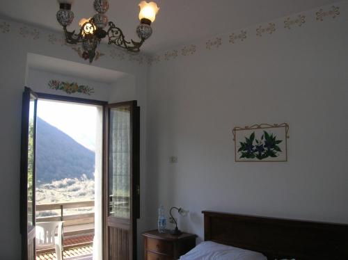 a bedroom with a bed and a window and a chandelier at Genziana B&B by VM in Opi