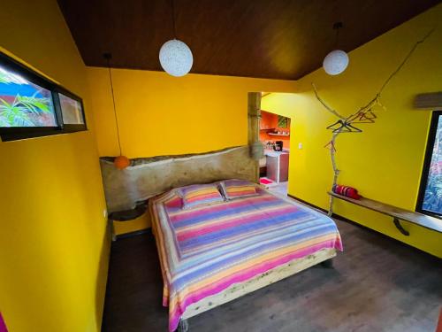 a bedroom with a bed in a yellow room at El Sol Monteverde in Monteverde Costa Rica