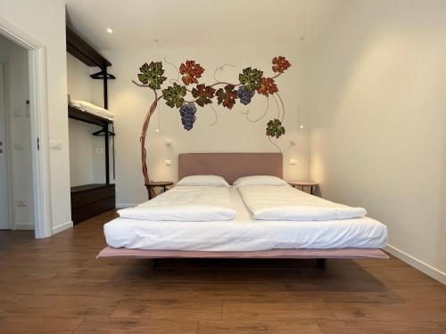 una camera da letto con un letto con una pianta sul muro di Agritur Fiore d'Ulivo a Riva del Garda