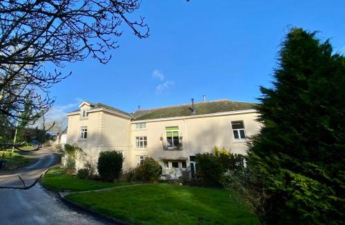 a large white house on a street at Halwell House - A Spacious Quiet Apartment in Kingsbridge