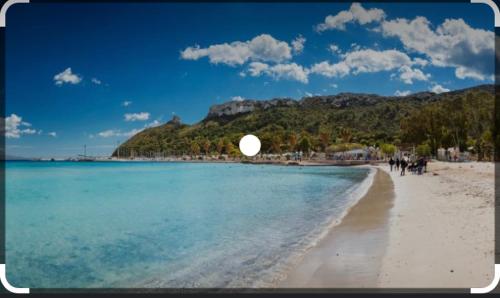 a beach with people walking on the sand and the water at Virgy’s House in Sestu