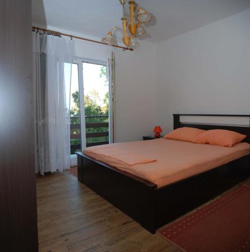 a bedroom with a bed and a large window at Apartments Kraj, Tratica Beach in Kraj