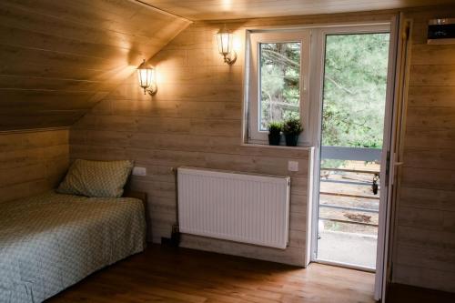 a small bedroom with a bed and a window at Kućerak Sofija in Čortanovci