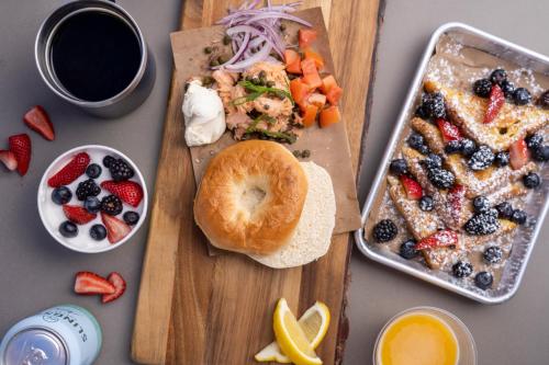 a table with a cutting board with a bagel and a plate of food at Under Canvas Bryce Canyon in Widtsoe