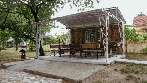a gazebo with a table and chairs in it at Kućerak Sofija in Čortanovci