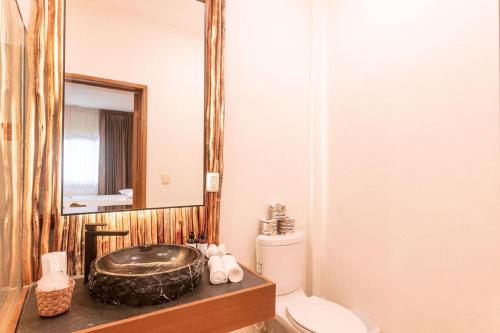 a bathroom with a sink and a toilet at Hotel Arena in Holbox Island