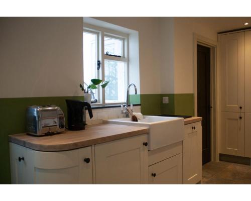 a kitchen with a sink and a window at Highday House - A Place To Escape To in Totnes