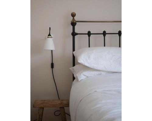 a bedroom with a bed and a lamp and a table at Highday House - A Place To Escape To in Totnes