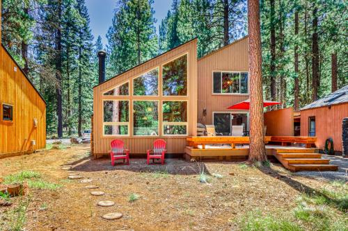 a house with two red chairs and a tree at Aspen House 21 in Black Butte Ranch