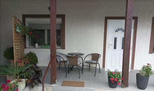 une terrasse avec une table et des chaises dans une maison dans l'établissement Apartman Ana 1, à Valpovo