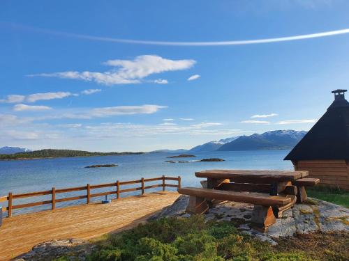 a picnic table next to a body of water at Off-the-grid cabin on the island of Senja in northern Norway in Vangsvik