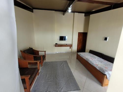 een kamer met een bed en een tv aan de muur bij Cobertura vista mar in Maricá