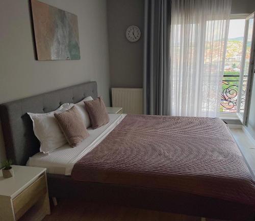 a bedroom with a large bed with a window at Downtown Apartments in Pristina