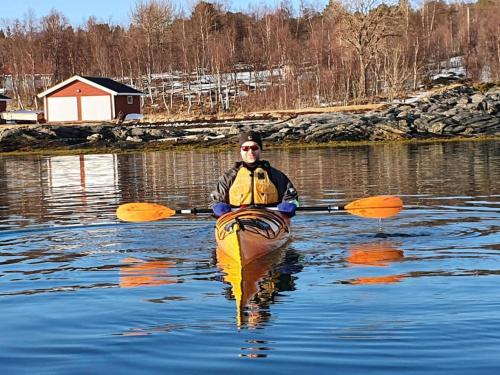 a man is in a kayak on a lake at Off-the-grid cabin on the island of Senja in northern Norway in Vangsvik