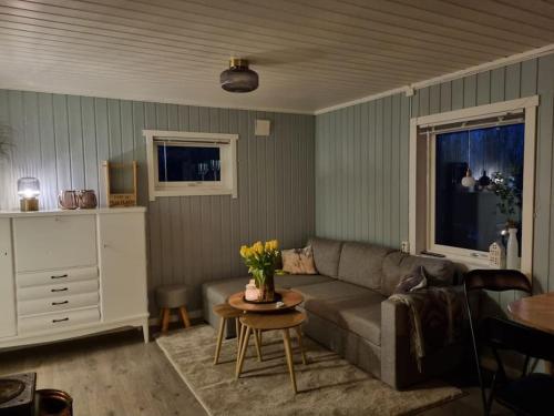 sala de estar con sofá y mesa en Off-the-grid cabin on the island of Senja in northern Norway, en Brygghaugen