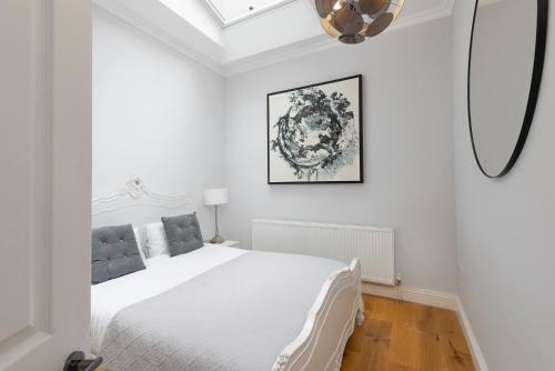 um quarto branco com uma cama branca e um tecto em PenthouseStays Notting Hill - Spacious 3 Bedroom King Bed Apartment - near Portobello Road & Kensington High Street em Londres