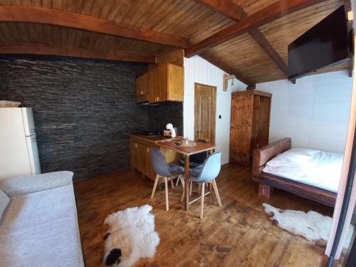 uma cozinha com uma mesa e cadeiras e uma cama em Cabana Everest View Buces -Vulcan Apuseni 