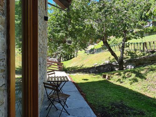 a porch with two chairs and a bench in a yard at Hotel Dente Del Gigante in Courmayeur