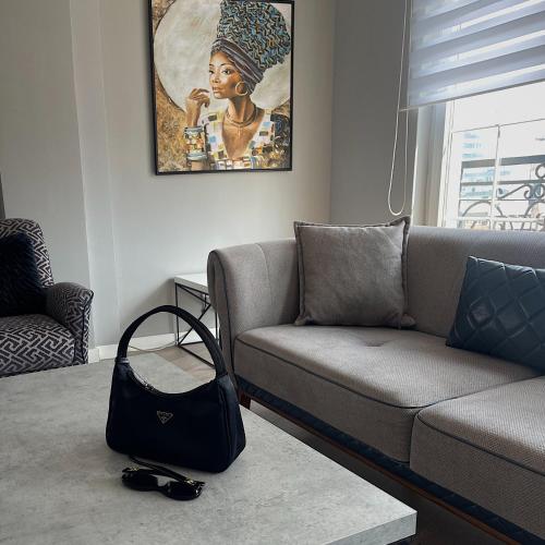 a living room with a couch and a black bag at Downtown Apartments in Pristina