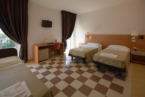 a hotel room with two beds and a desk at Domus Stella Maris - Casa per Ferie in Ancona