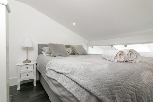 a white bedroom with a bed with towels on it at King Pin Corner in Stevenage