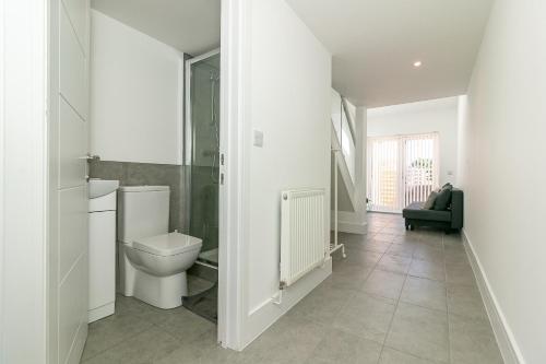 a white bathroom with a toilet and a sink at King Pin Corner in Stevenage