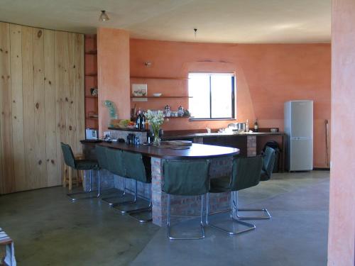 a kitchen with a bar with chairs and a sink at Casa Dos Milagres Holiday Home in Agulhas