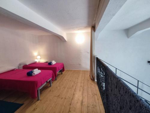 2 Betten in einem Zimmer mit rosa Bettwäsche in der Unterkunft Casa Cubino in Gioiosa Marea