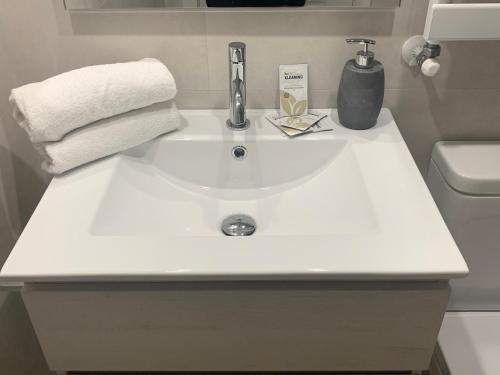 a white bathroom sink with a soap dispenser and towels at Ripera Panticosa in Panticosa