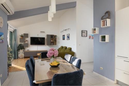 a dining room and living room with a table and chairs at Apartment by the sea in Podgora