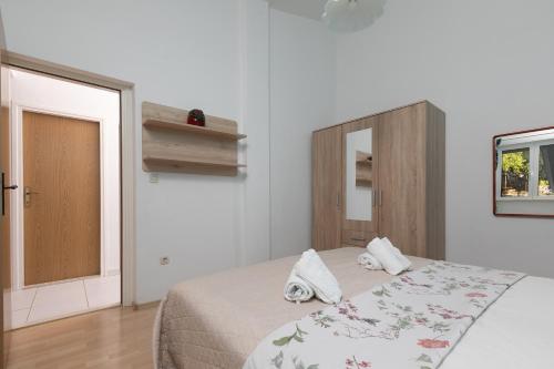 a bedroom with a bed with towels on it at Apartment by the sea in Podgora