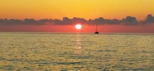 a sail boat in the ocean at sunset at Casa Giada sul mare in Torrenova