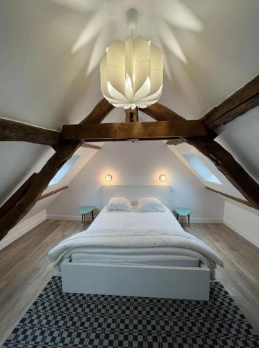 une chambre avec un grand lit dans un grenier dans l'établissement L'appart'2 charme, bord de mer., à Saint-Valery-en-Caux