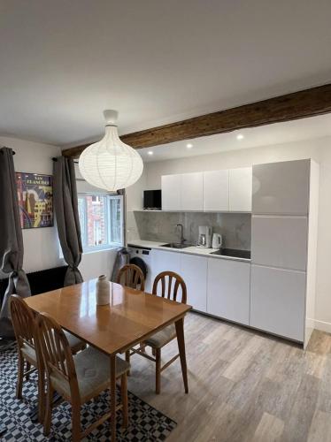 une cuisine avec une table en bois et une salle à manger dans l'établissement L'appart'2 charme, bord de mer., à Saint-Valery-en-Caux