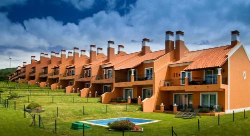 a row of orange apartment buildings with a pool at Dolce CampoReal Lisboa in Turcifal