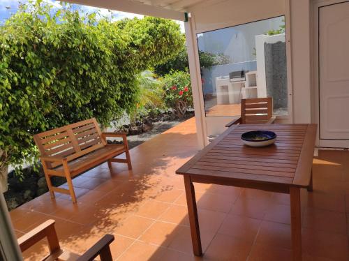 a wooden table and chairs on a patio at Casa de los pajaritos. in Charco del Palo