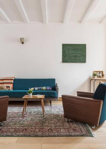ein Wohnzimmer mit einem blauen Sofa und einer Tafel in der Unterkunft Maison atypique au sein du joli village de Trentemoult in Rezé