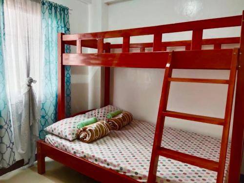 Letto a castello rosso con cuscino e scala di Vacation House in Baguio with Amazing Sunset Views a Baguio