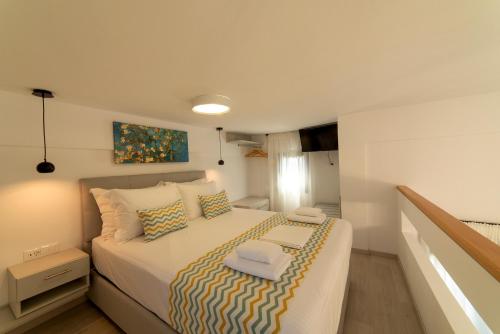 a small bedroom with a bed with white sheets and pillows at Emmy Villa in Anevató