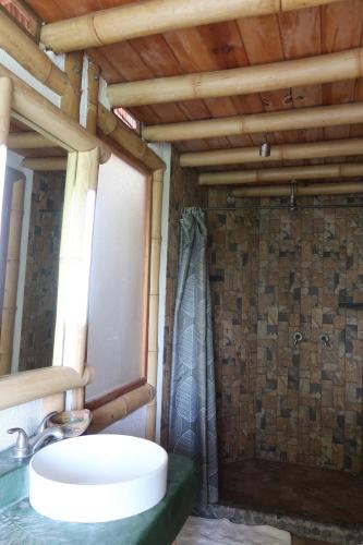 a bathroom with a sink and a shower at Bambu Guest House in Tzununá