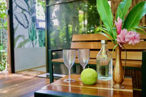 a table with two glasses and a vase and a lime at TERMINAL VERDE PRIVATE APARTMENTS NEAR AIRPORT 24h SELF CHECK IN in Concepción