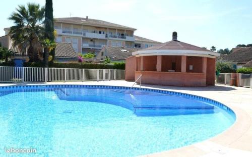 une grande piscine bleue devant un immeuble dans l'établissement Mazet Tahiti Parc, au Lavandou