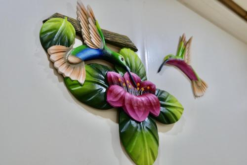 a decoration of a bird and flowers on a wall at TERMINAL VERDE PRIVATE APARTMENTS NEAR AIRPORT 24h SELF CHECK IN in Concepción
